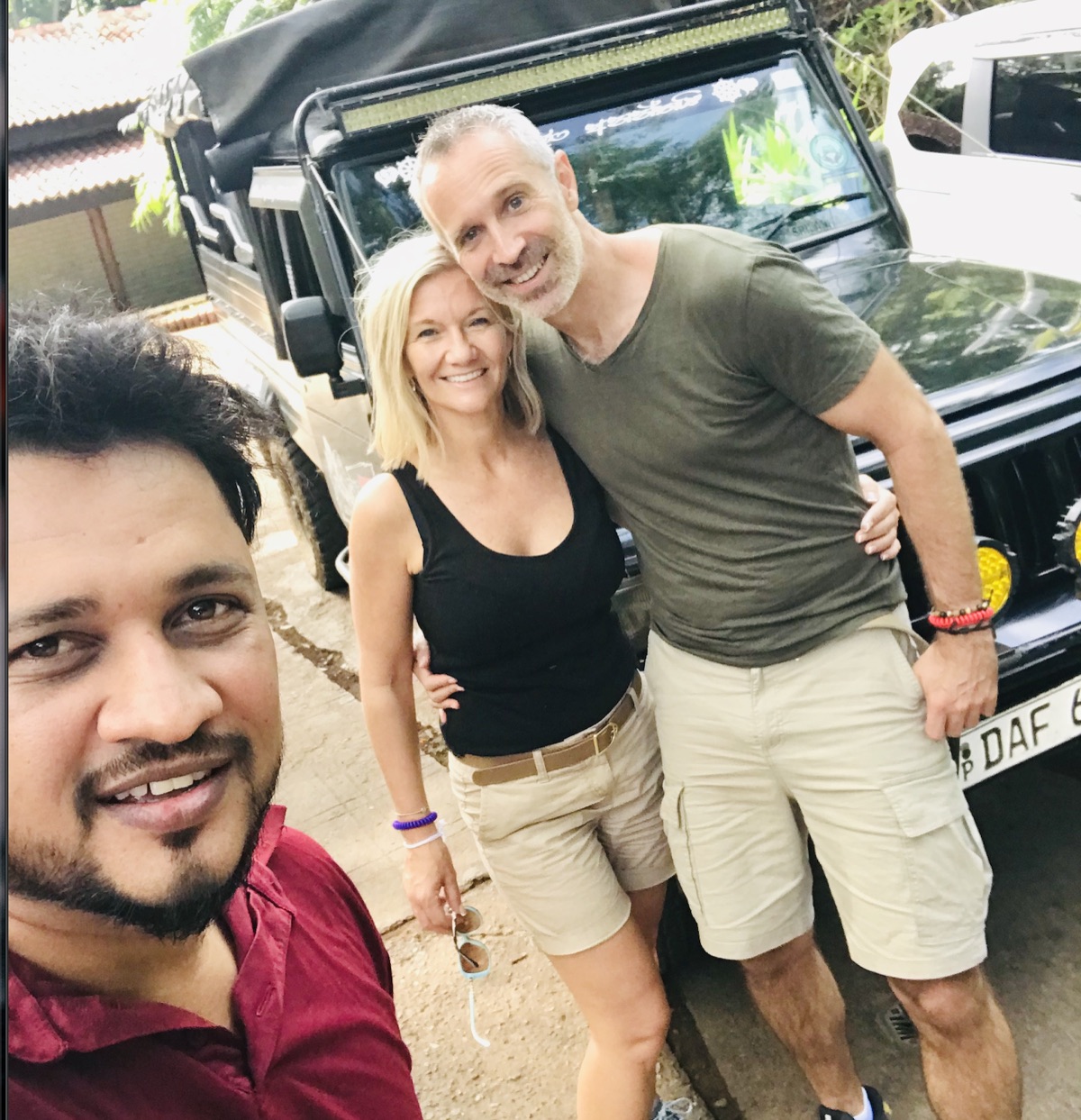 Nishan with travellers beside their safari vehicle